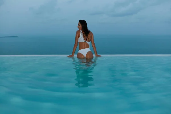Sommarlovet. Kvinna i baddräkt i Infinity swimming pool — Stockfoto