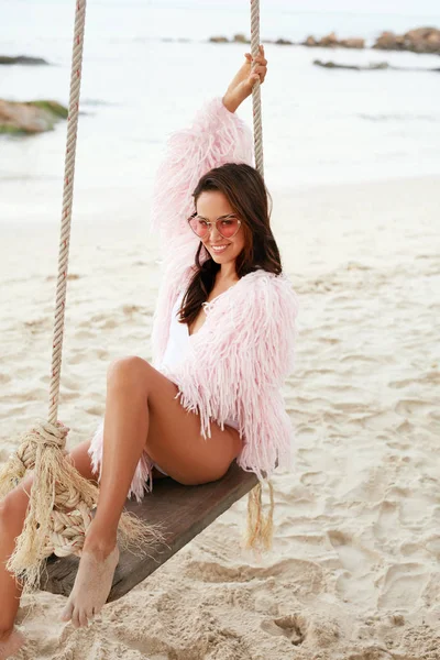 Zomer mode. Gelukkig modieuze vrouw model op strand schommel — Stockfoto