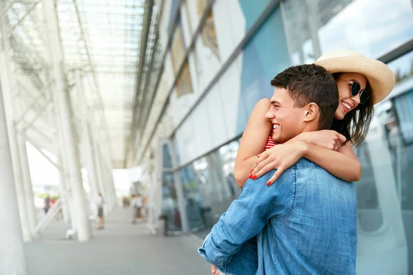 Una pareja se encuentra después de mucho tiempo. Gente feliz abrazándose cerca del aeropuerto — Foto de Stock