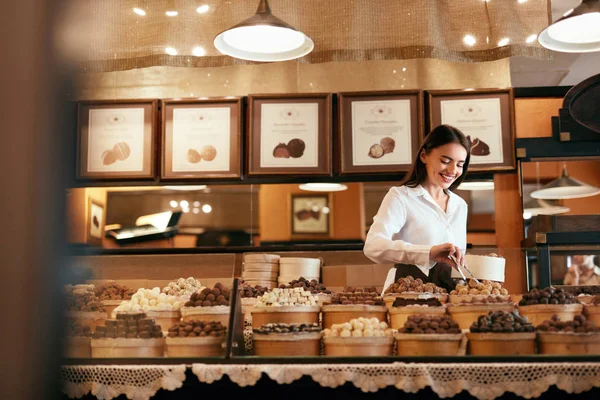 Konfektyr. Kvinna som säljer choklad godis i butik — Stockfoto