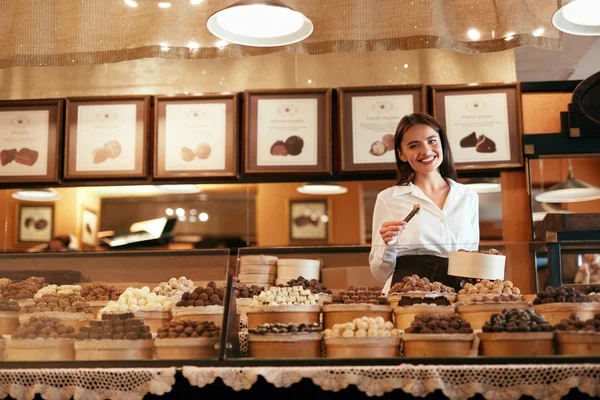 Choklad butik. Kvinnliga säljaren i Konfektyr Shop. — Stockfoto