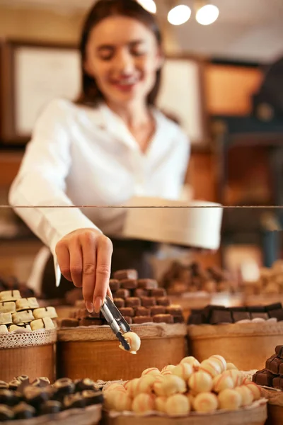 Konfektyr. Kvinna som säljer choklad godis i butik — Stockfoto