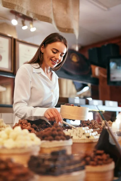 Konfektyr. Kvinna som säljer choklad godis i butik — Stockfoto