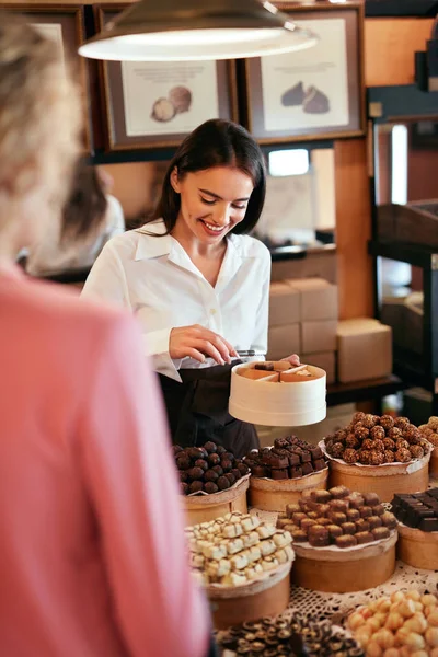 Loja de Chocolate. Mulher vendendo doces de chocolate e doces — Fotografia de Stock