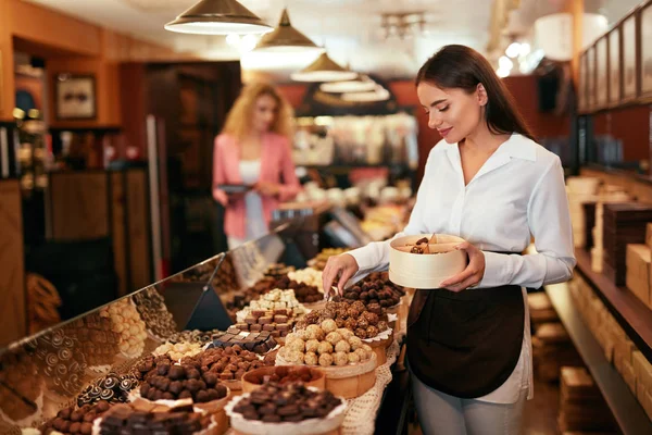 Chokladbutiken. Kvinna som arbetar i choklad butik — Stockfoto