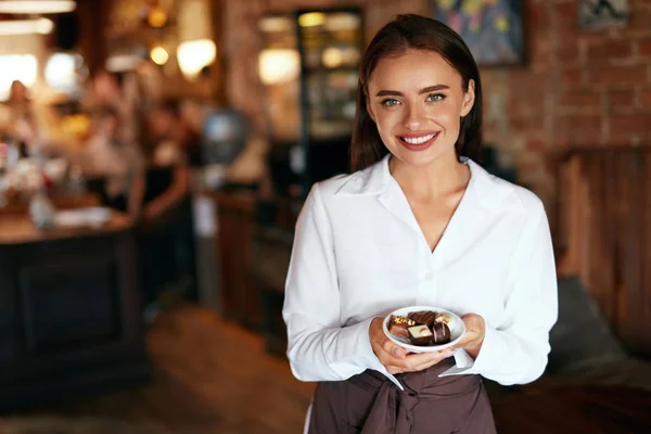 Servitris i Café. Kvinna med choklad godis i Konfektyr — Stockfoto