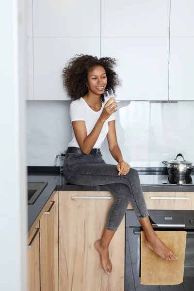 Bois de l'eau. Femme heureuse avec verre d'eau douce dans la cuisine — Photo