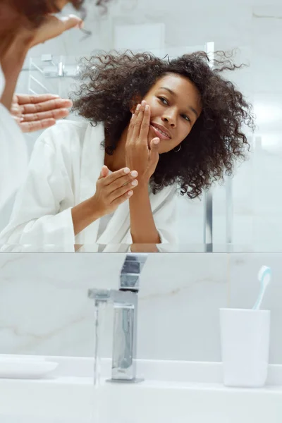 Cuidado com a pele. Mulher lavando rosto com água na pia no banheiro — Fotografia de Stock