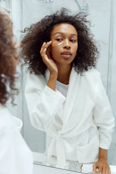 Eye skin beauty. Woman apply eye patch mask on face at bathroom — Stock Photo, Image