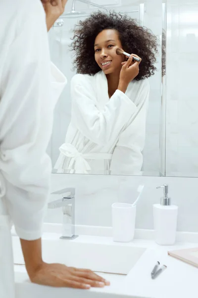 Maquiagem de beleza. Mulher aplicando cosméticos no rosto no banheiro — Fotografia de Stock