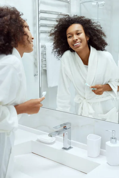 Woman with smile and beauty face looking in mirror at bathroom — Stock Photo, Image