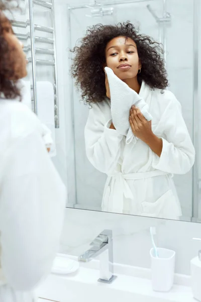 Gezicht wassen. Vrouw drogen huid met handdoek in de badkamer — Stockfoto