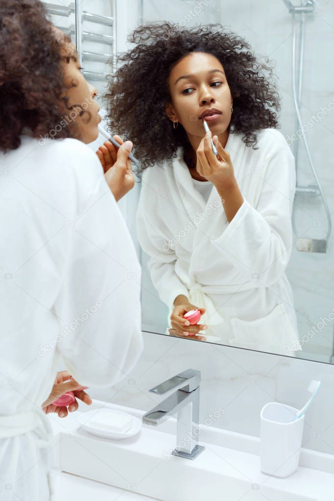 Lips skin care. Woman applying lip balm with makeup brush 