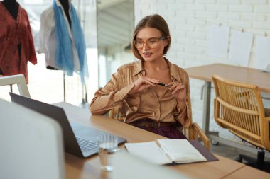 İş yerinin sahibi. Moda tasarımcısı dizüstü bilgisayarda çalışıyor ve trendleri düşünüyor. Başlangıçtan Başarılı Girişimciye ve Kendi Giysi Üretimi Atölyesinde.