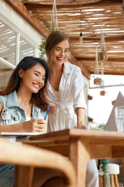 Business. Women At Cafe With Laptop. Comfortable Digital Nomad Lifestyle With Modern Technologies. Beautiful Girls In Stylish Outfit Enjoying Summer Vacation And Working Online.
