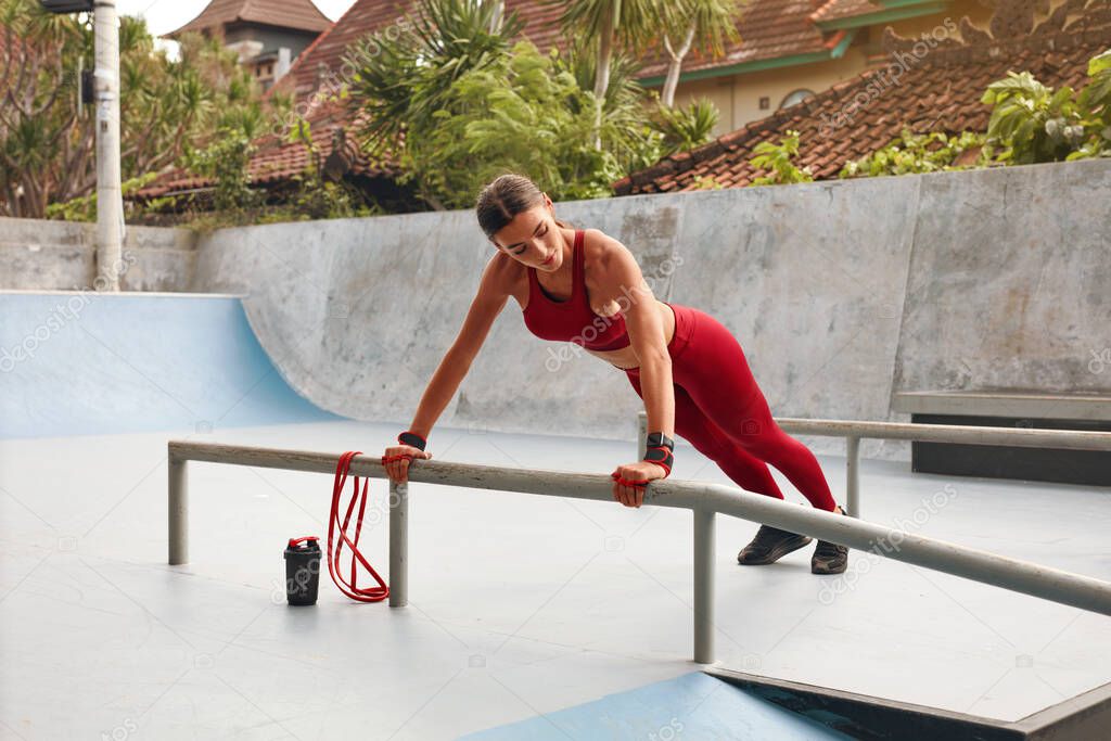 Fitness Girl Warming Up On Stairs Before Workout. Fit Woman In Fashion Sporty Outfit Exercising On Stadium. Protein Shake For Strong Muscular Body. Outdoor Training For Active People In City.