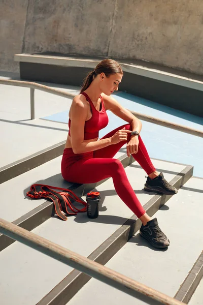 Sport. Vrouw maakt gebruik van Fitness Tracker voor het controleren van Workout Progress. Fit meisje met perfecte lichaam in sportkleding monitoring hartslag op Smart Watch. Sportieve vrouw op stedelijke stijl achtergrond. — Stockfoto