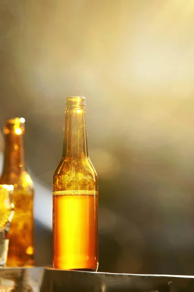 Flaskor med öl på bordet utomhus närbild — Stockfoto