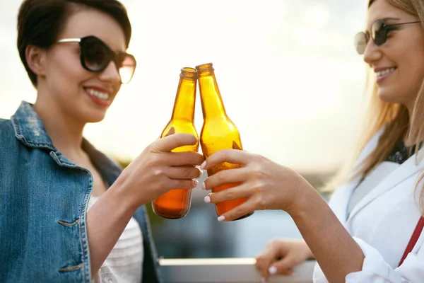 Женщины пьют пиво из бутылок на открытом воздухе — стоковое фото