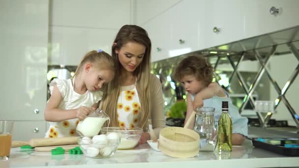 Moeder met dochters koken eten in moderne lichte keuken — Stockvideo