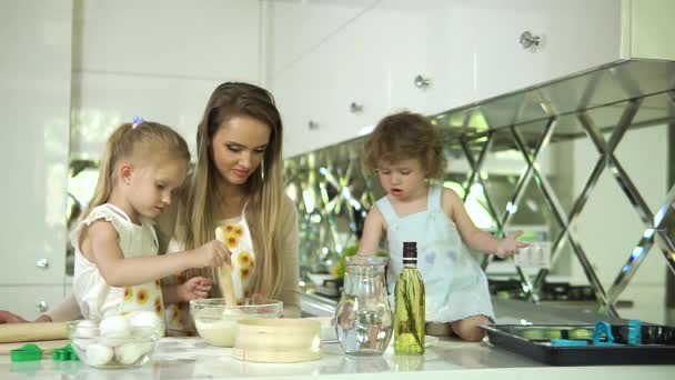 Mãe com filhas cozinhar alimentos na cozinha moderna luz — Vídeo de Stock