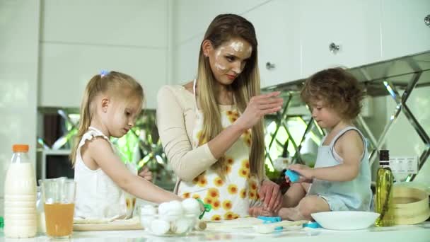 Hornear en familia. Madre con hijas preparando comida en la cocina — Vídeo de stock