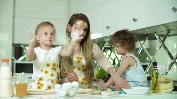 Hornear en familia. Madre con hijas preparando comida en la cocina — Vídeo de stock