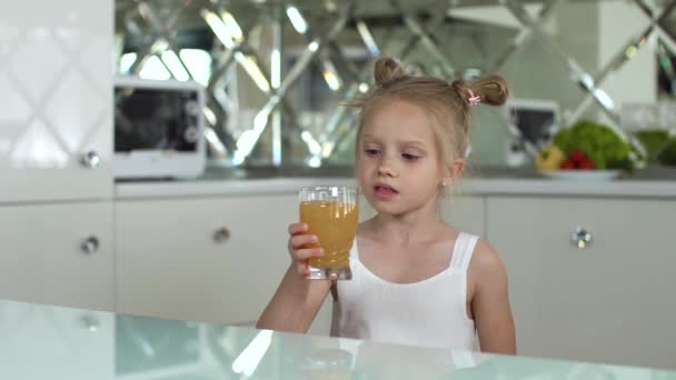 Nutrición infantil. Niña bebiendo jugo en la cocina — Vídeo de stock