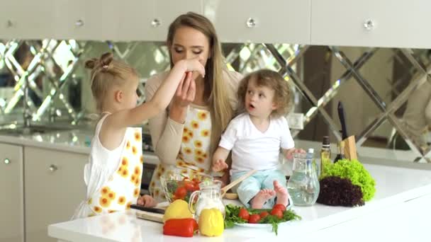 Jovem mãe com crianças cozinhar alimentos saudáveis na cozinha — Vídeo de Stock