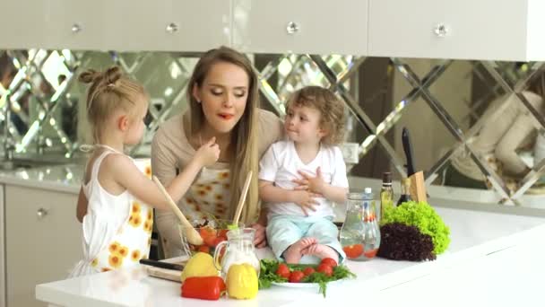 Jovem mãe com crianças cozinhar alimentos saudáveis na cozinha — Vídeo de Stock