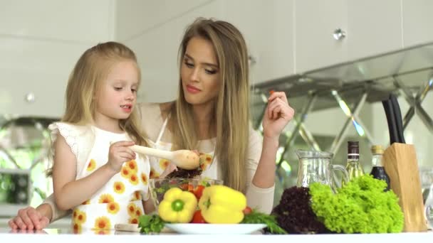 Mãe com filha cozinhar salada de legumes na cozinha em casa — Vídeo de Stock