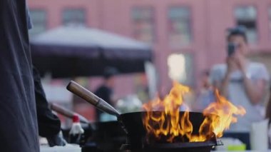Sokak Yemeği. Şef dışarıda ateşte Tayland yemeği pişiriyor.