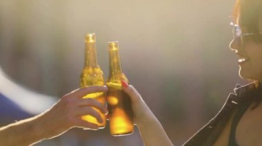 Çekici bir kadın dışarıda arkadaşlarıyla bira içiyor.