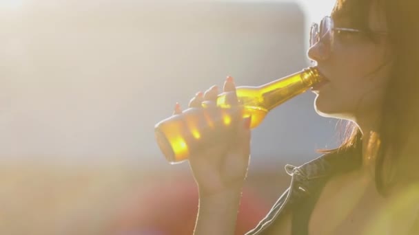 Mujer joven bebiendo cerveza de la botella al aire libre — Vídeos de Stock