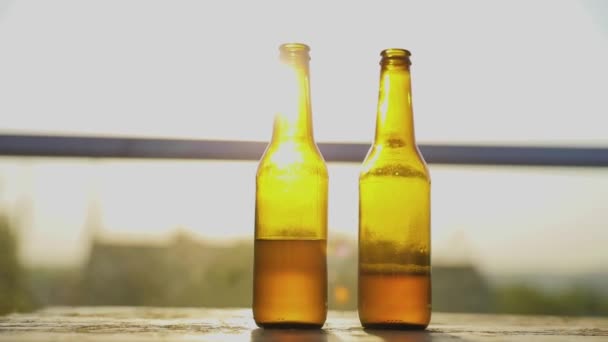 Бутылки пива на столе крупным планом с солнечным светом на фоне — стоковое видео