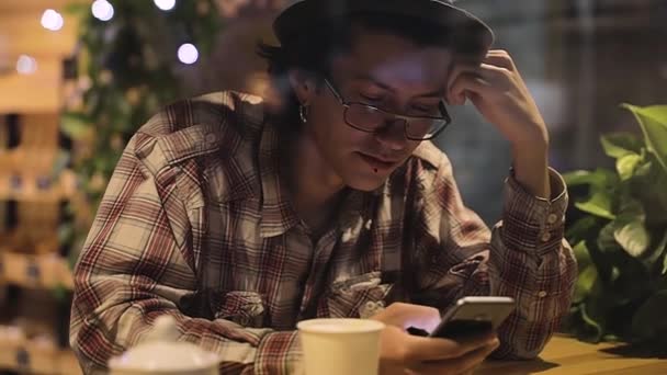 Retrato de hombre con estilo con teléfono móvil en el café — Vídeos de Stock