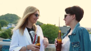 Dışarıda bira içen, dışarıda eğlenen genç kadınlar.