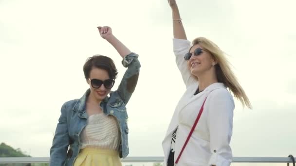 Lächelnde Frauen, die Spaß haben, Bier trinken und draußen tanzen — Stockvideo