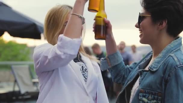 Glimlachende vrouwen hebben plezier, drinken bier en dansen buiten — Stockvideo