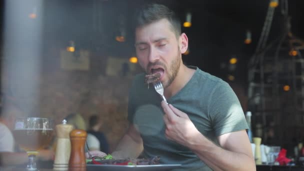 Hombre comiendo comida en el restaurante, Hombre disfrutando de filete de carne — Vídeo de stock