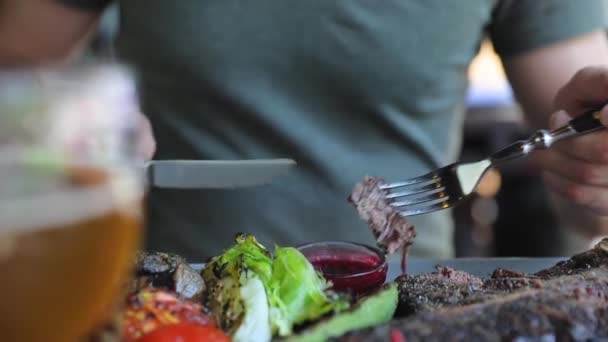 Mann beim Abendessen im Restaurant. Großaufnahme Mann isst Steakfleisch — Stockvideo