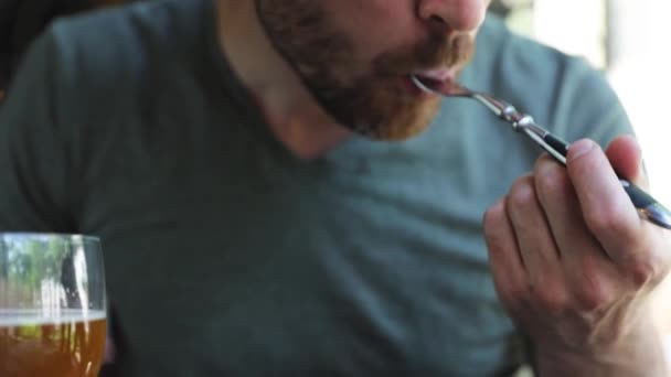 Homem comendo comida e bebendo cerveja no restaurante — Vídeo de Stock