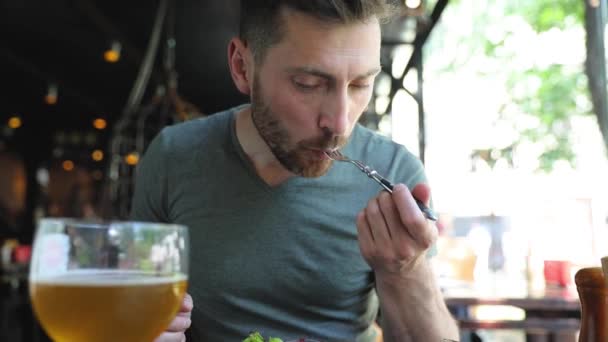 Muž jíst jídlo a pití piva v restauraci — Stock video