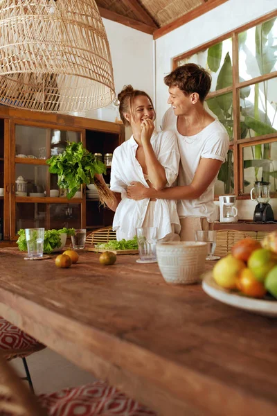 Cuisiner. Couple Préparation de légumes biologiques frais pour la salade. Homme câlins femme à la cuisine dans la villa tropicale. Alimentation saine avec des vitamines naturelles en vacances d'été, lune de miel ou week-end romantique. — Photo