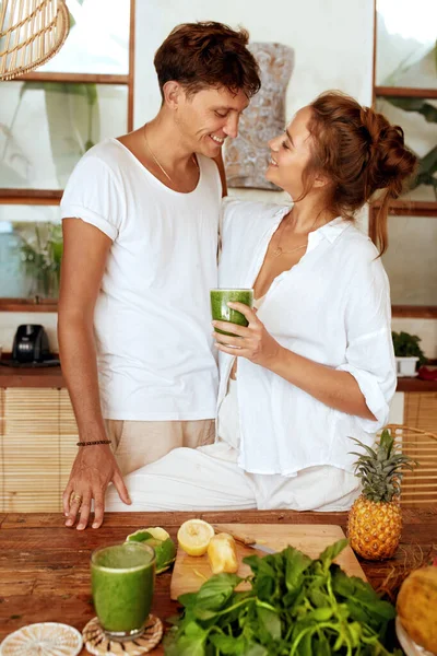 Mutfaktaki adam ve kadın. Elinde bir bardak detoks kokteyliyle ayakta duran romantik bir çift. Doğal vitaminler, taze organik meyveler ve sağlıklı beslenme için sebzeler.. — Stok fotoğraf