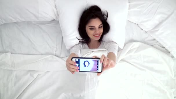 Krásná žena tvorby fotografie na mobilním telefonu v posteli — Stock video