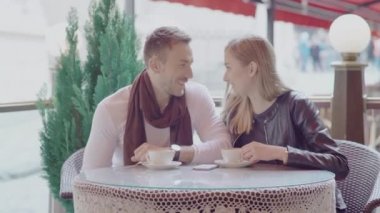 Caddedeki kafede kahve içen romantik çift.