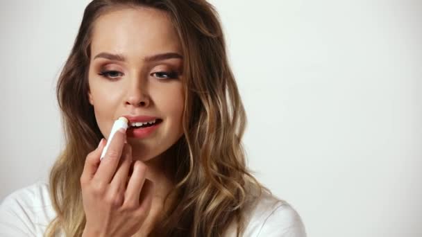 Cuidado de la piel de labios. Mujer con maquillaje de belleza aplicando bálsamo en los labios — Vídeos de Stock