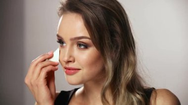Güzellik makyajı. Süngerle Yüze Kozmetik Uygulayan Kadın