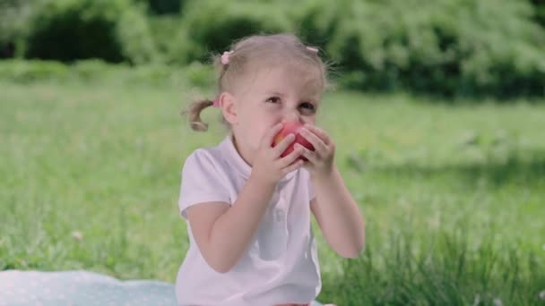 Hälsosam kost. Barn äter saftiga äpplen utomhus — Stockvideo